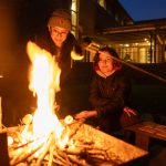 ○ Two students roast marshmallows at a camp fire in the Stanton Hall courtyard.
