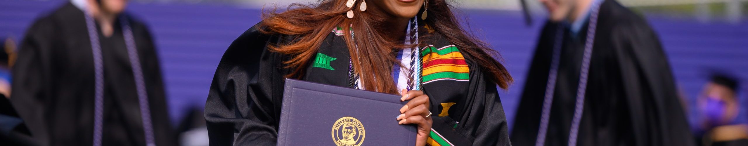 A student shows her diploma during graduation